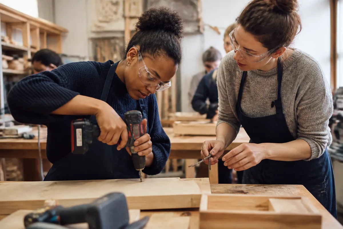 Cours de bricolage pour femmes avec apprentissage du perçage et de la fixation sur un panneau en bois